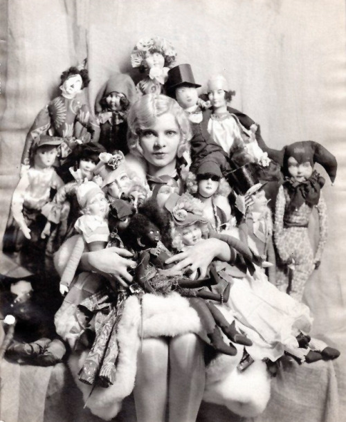 stalinwasabasicbitch:

dollmixture:

American actress Claire Luce with a gaggle of boudoir dolls, 1920s

Sydneyflapper, I have to thank you for introducing me to boudoir dolls. I was recently reading Empty Mansions: The Mysterious Life of Huguette Clark and the Spending of a Great American Fortune and the author commented on this photograph of Huguette (with boudoir doll in hand): 
“Huguette’s attachment to her dolls was indeed unusual. A photograph survives of a Clark dinner party in a restaurant, with a group including Anna and Huguette, who looks to be about sixteen, so this would be about 1922. Next to one of the men in the photo is Huguette, wearing a party dress and a strand of pearls, her eyes fixed on something in the distance. In her lap, she holds a doll with well-coiffed coal-black hair, wearing its own party dress.”
It may not have been so ‘unusual’ had the author known about the fashion for boudoir dolls out and about! Thank you for giving me that info :) 


What a fabulous image - the Huguette Clark book is on my reading list. And you&rsquo;re right - it does seem less odd to see one in this context if one knows that they often had a &ldquo;mascot&rdquo; status and weren&rsquo;t made for children. 

I had a chuckle when I saw the image of Claire Luce with her dolls - if I didn&rsquo;t keep my Boudoir Doll fascination sternly in check and limited to handful of them, I&rsquo;d wind up buried like her. Looks like there are some nice silk faces in the bunch&hellip;possibly even Lencis?