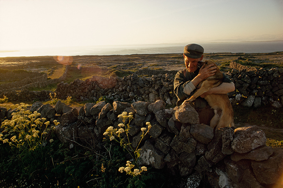 A farmer embraces his dog in his stonewalled field on Inishmore Island in Ireland, March 1971.Photograph by Winfield Parks, National Geographic Creative