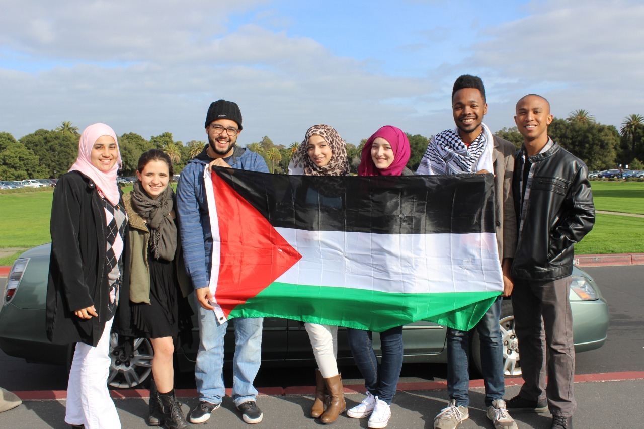 7 Black and Brown young people hold a Palestinen flag to kick off the 