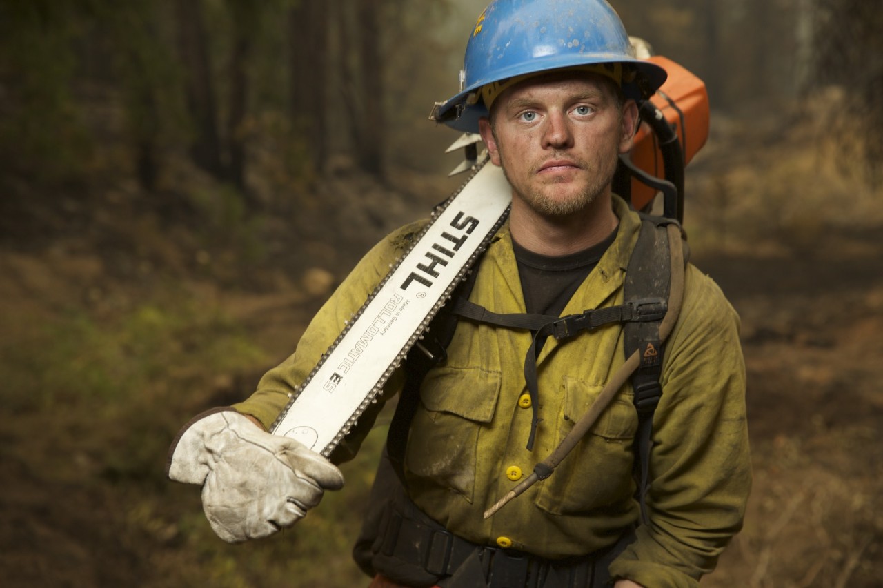 Capturing Portraits on the Fire LineNational Geographic photographer Mark Thiessen is our inside man when it comes to stories about fire. He has photographed several wildfire stories and is a trained firefighter himself. Recently, he embedded with one team fighting a group of fires near Hayfork, California. Go to our sister blog Proof to see all the portraits and read his first-person account about working with the firefighting crew.  During the 20 years I have been shooting wildfires there is one thing that always stands out: the faces. They have that “50-foot stare in a 10-foot room” gaze. Who could blame them after working 21 days straight? A few weeks ago I spent a week with a hand crew from the Salt Lake Unified Fire Authority. (See the story on Nat Geo News, A Photographer Inside the Wildfires ) Although they usually work 14 days, they were extended to 21 because it was such a frantic fire season. Three weeks of hard work in hot, dusty, smoky conditions—combined with accumulated sleep deprivation—can really take its toll, and it shows on their faces.Here&rsquo;s how I capture these portraits on the fire line. First I look for a background that has some depth and the residual smoke of a burned-out area helps with this effect. Next I set up a soft box with a Canon Speedlite 600-EX-RT strobe inside. This is the same kind of strobe you would place on top of your camera, but I’m putting it in a softbox. For those who don’t know, a softbox is kind of like a tent that diffuses the light. The larger the softbox, the softer the light. I placed the softbox on a light stand pointing at the subject and shot below it.[[MORE]]I make several test shots and adjust the strobe so the light falling on the subject balances with the ambient light falling on the background. Although I’m using a 24-70mm zoom lens, I prefer to back off and zoom in to avoid wide-angle distortion. I also set my aperture at f/4 for shallow depth of field. I want the background to go out of focus. I don’t really pose them. I draw a line in the dirt with my foot and tell them to stand just behind it. Depending on the person, a firefighter will stand very straight and rigid. In this case I just ask them to shift their weight from one foot to another. I shoot them loose, tight, and tight horizontal portraits. Time is of the essence so I don’t shoot more than a few of each composition.I try to select a spot where I’m away from the rest of the fire crew. They are tight like family and love to tease the person being photographed. As you can tell, there&rsquo;s a lot that comes together to make these portraits. But in the end it is simply these firefighters that carry the day.– Mark Thiessen, National Geographic Photographer Click here to see wildfire photos from the Your Shot community. 