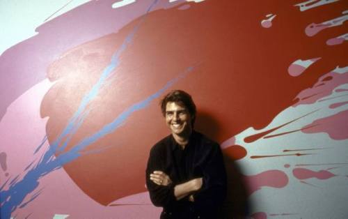 Actor Tom Cruise standing in front of red abstract painting on wall  of disco.
Location:Charlotte,  NC, USDate taken:December 1989
Photographer:Ted  Thai