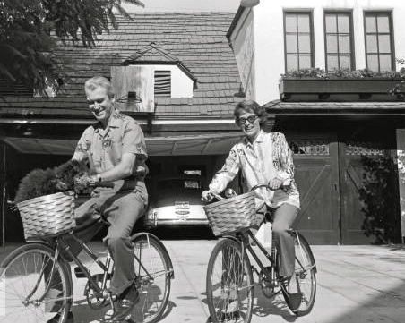 Jimmy Stewart and Gloria Hatrick McLean ride bikes. (And their dog rides, too.)