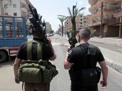 gunrunnerhell:  Afternoon walk… Two Sunni gunmen stand in the middle of Syria Street which divides the Sunni and Alawite areas, in the northern port city of Tripoli, Lebanon, Sunday May 13, 2012. (AP Photo/Hussein Malla) (The gunman on the left has
