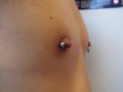 apadravya-piercing:  Combo piercing – one horizontal barbell piercing in the right nipple, and in the left, a vertical barbell piercing with a captive bead ring piercing.