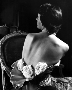 onlyoldphotography:  Nina Leen: Model wearing mother-of-pearl satin gown by Balmain featuring three huge roses tucked in a shell-shaped waist. NY, 1949 