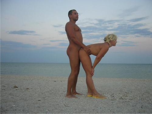 Nudist family at nude beach playing