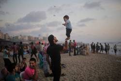 heart-full-of-islam:  thebowspring:  A Palestinian father playfully balances his son on his right hand at the beach in Gaza City early one evening. The coast of Gaza has grown increasingly popular over the years. It had always been a sight for weary eyes