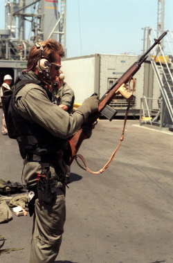 house-of-gnar:  house-of-gnar:  A US Navy SEAL checks out his M14 7.62mmx51mm rifle. Note the customized fore grip fitted to the weapon. This photo was taken in Feb 1991. During this period SEAL Team 8 carried out a series of ship boarding operations