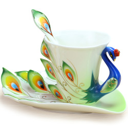 quicksilver-ink:  [A collection of teacups and matching saucers with a shared peacock motif. The bird’s head, neck and body form the handle; the tailfeathers are painted on the sides of the cup and then fan out behind, peeling away from the cylinder