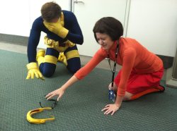 daggerpen:   Image Caption: A picture of two cosplayers, one cosplaying Velma from Scooby Doo and one cosplaying Cyclops from the X-Men. Both kneel on the floor groping around with their hands; Cyclops covers his eyes, while Velma has hers squinted. On