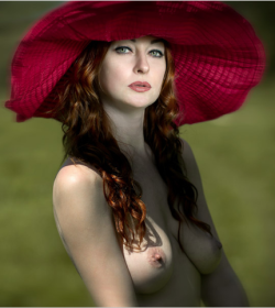 Gorgeous redhead with pretty eyes topless in a sun hat.