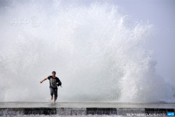 afp-photo:SAUDI ARABIA, Dhuba : A Saudi man runs in front of a big wave as high winds batter the coast on February 11, 2015 in the Saudi Red Sea port  city of Dhuba, located in Tabuk Province, northwest of the Saudi capital  Riyadh.  AFP PHOTO / MOHAMMED