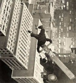 A man balancing on a piece of wood on the roof of a skyscraper, 1939.