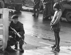 historicaltimes:  Irish girl overlooks a British Soldier during the Troubles, Northern Ireland. - c. 1970. via reddit 