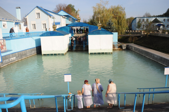 Women with a girl praying before plunging into St. Anna`s holy water.