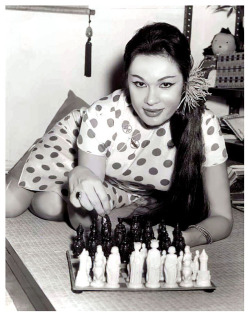 burleskateer: Danielle Dao Tien     aka. “The Eurasian Beauty”.. Vintage press photo dated from 1962 features Ms. Dao Tien playing chess, as she claimed to be unable to find work as an exotic dancer.. While dancing in Miami, she’d incurred the