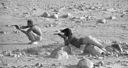 Steve McQueen and his wife, Neile Adams, firing pistols in the Palm Springs desert.