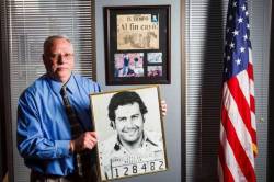 The DEA&rsquo;s new Houston Division Chief, Javier Pena, holds a photo of the first booking mug shot of Pablo Escobar that he got while working on the case years earlier, while at his office, Tuesday, Feb. 28, 2012, in Houston. On the wall behind Pena