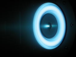 The Engine Burns Blue This image shows a cutting-edge solar-electric propulsion thruster in development at NASA&rsquo;s Jet Propulsion Laboratory, Pasadena, Calif., that uses xenon ions for propulsion. An earlier version of this solar-electric propulsion