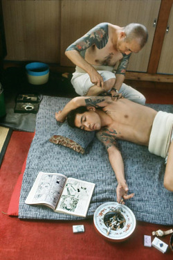 s-h-o-w-a: Man reading comics while being tattooed, Tokyo, Japan, 1970   by Martha Cooper 