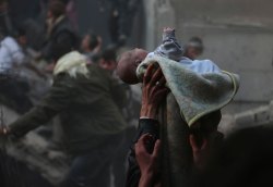 Men hold up a baby saved from a pile of rubble. Damascus, Syria, 2014