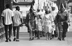 historynet:  Two young black men pass Ku Klux Klan marchers in downtown Salisbury, August 1964. [2,100 x 1,359]