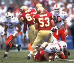 siphotos:  Dwayne Johnson - better known to pro wrestling fans as “The Rock” - makes a tackle during a 1993 Miami-Florida State game as Ray Lewis (No. 52) watches in the background. (Damien Strohmeyer/SI) GALLERY: Classic Photos of Miami Hurricanes