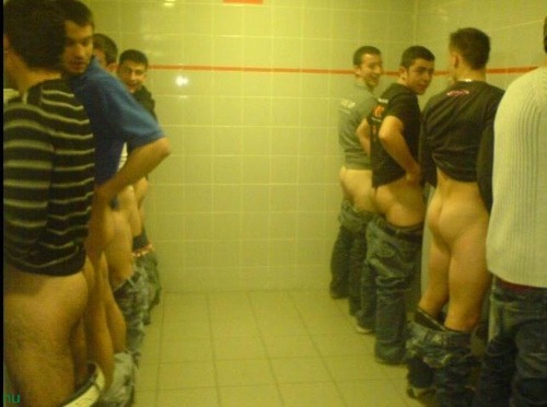 Naked guys pissing at urinal
