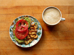 garden-of-vegan:  Roasted garlic toast topped with mashed avocado, sliced tomato, salt, pepper, and lime. Roasted cashews and coffee with vanilla soy milk. 