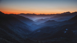 capturedphotos:    The sun sets behind the most distant mountain. The breeze feels that much crisper on your bare skin. You see the fog rolling lazily along the mountain tops off in the distance. The sky’s hues shift to these warm tones while everything