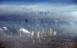 fotojournalismus:  An aerial view of smog over skyscrapers of the metropolis of Manila, Philippines on November 24, 2013. [Credit : Dennis M. Sabangan/EPA] 