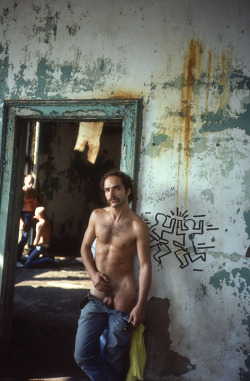 retrofap:  J.D. Slater Pier 46 (Peter Get His Dick Sucked) - by Stanley Stellar 1981 (In the background is photographer Peter Hujar having sex while Slater leans against a doorway alongside graffiti by Keith Haring) 