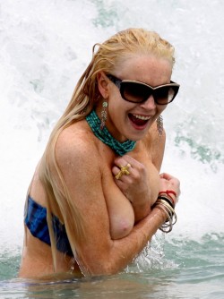 celebpaparazzi:Lindsay Lohan loses her top in the surf at Miami Beach (May 23rd, 2011)