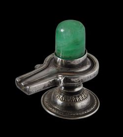hinducosmos: Emerald Shiva Lingam 19th century India. Silver Shiva lingam set height of emerald: 3.4cm, weight of emerald: 188.88carats Overall height: 7.5cm, length: 7.3cm, width: 4.8cm, combined weight: 125g (via Michael Backman Ltd)