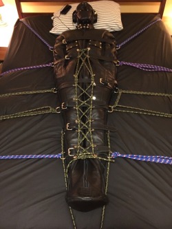 feelingknottycda:Leather belts cinched tightly, laced up tightly from ankles to chest, and secured with ropes at every anchor point, the hooded, muzzled, sleepsacked leather gimp is ready for a long, secure, and comfortable programming session.