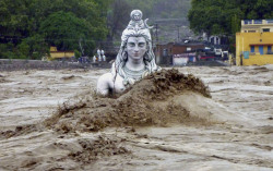 sixpenceee:  Statue of Shiva, nearly submerged in India’s floodwater. 