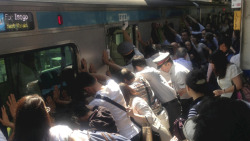  Japanese commuters push 32-ton train to free woman TOKYO Dozens of Japanese train passengers pushed a 32-ton train carriage away from the platform to free a woman who had fallen into the eight-inch gap between the train and platform during the busy