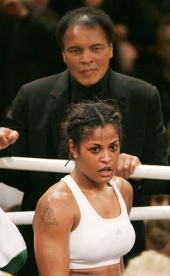 kingpinnn:  U.S. boxing legend Muhammad Ali (top) smiles as he stands behind his Daughter Laila Ali, after her super-middleweight fight against Asa Sandell of Sweden in Berlin December 17, 2005 