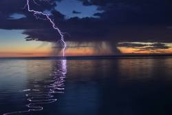 sixpenceee:  Surreal lightning over a calm ocean.  