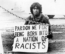 black-australia:  An iconic image showing Aboriginal rights activist, Gary Foley with a placard reading, “Pardon me for being born into a nation of racists”. 