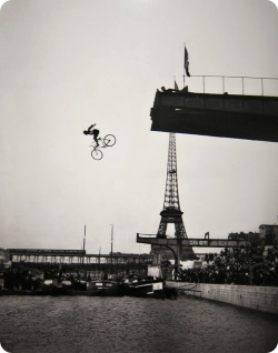 A l’île des Cygnes à Paris près de la Tour Eiffel, le saut de la mort par Peyrusson, dans la Seine (plongeur s’élançant dans le vide sur un vélo), 1912.