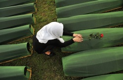 politics-war:A Bosnian Muslim woman mourns over the casket of a relative, one of 409 newly-identified victms of the 1995 Srebrenica massacre, at the Potocari Memorial Center in Srebrenica, Bosnia, on July 10, the day before Thursday’s burial ceremony.