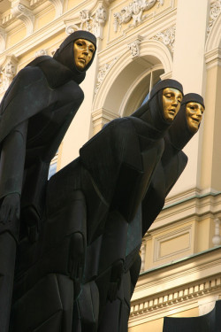 slacktivities:  jeannepompadour:  Black-robed, gold-faced muses symbolizing Drama, Tragedy and Comedy on the facade of the National Drama Theatre in Vilnius, Lithuania  