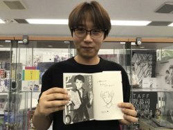 Hanamura Yaso, the author of the anime production manga, ANIMETA! (Animator!), shares photos of SnK Animation Director Asano Kyoji after meeting him at WIT Studio! Asano is posing in front of the merch display, which has plenty of SnK items.More on