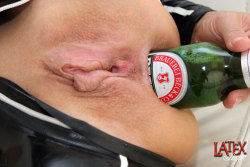 latexangelxxx:  Latex Angel  stuffing her holes with beer bottles. 