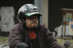 The face the man makes while riding his motorcycle. Bandung, Indonesia