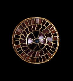 Gold disc brooch, Merovingian, probably from Germany, late 6th. The brooch is made in cloisonne technique with garnets and glass, adopted from Eastern Mediterranean jewelers by the Franks, Goths, Lombards and other &ldquo;barbarians&rdquo;. The wearing
