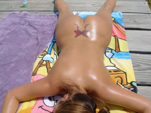 Oiled nude girl sunbathing