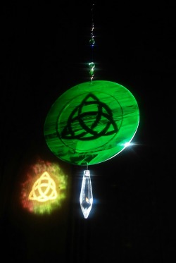 ornamentalglass:  Triquetra Rainbowlightcaster with Green Man on reverse side.  My Rainbowlightcasters reflect their image with direct light.  They cast a colorful halo around the image, have a second design on the back and the crystal refracts rainbows