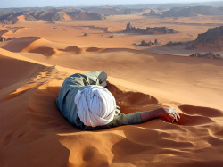 A Tuareg guide rests at the summit of Tin-Merzouga, the largest dune (or erg) in the Tadrart region of the Sahara desert in southern Algeria. Photograph by Evan Cole